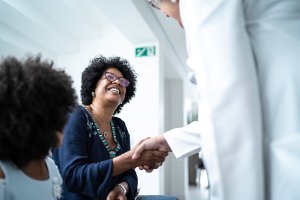 Patient smiling shaking doctors hand