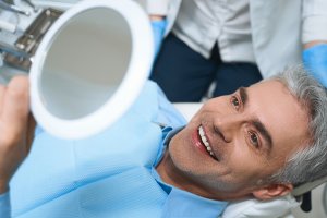 Man smiling into mirror