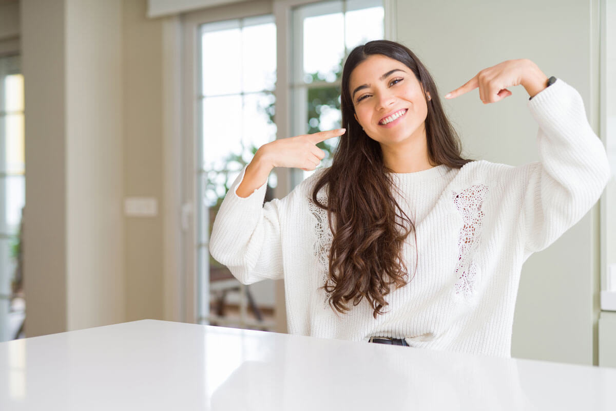 Girl pointing to teeth smiling